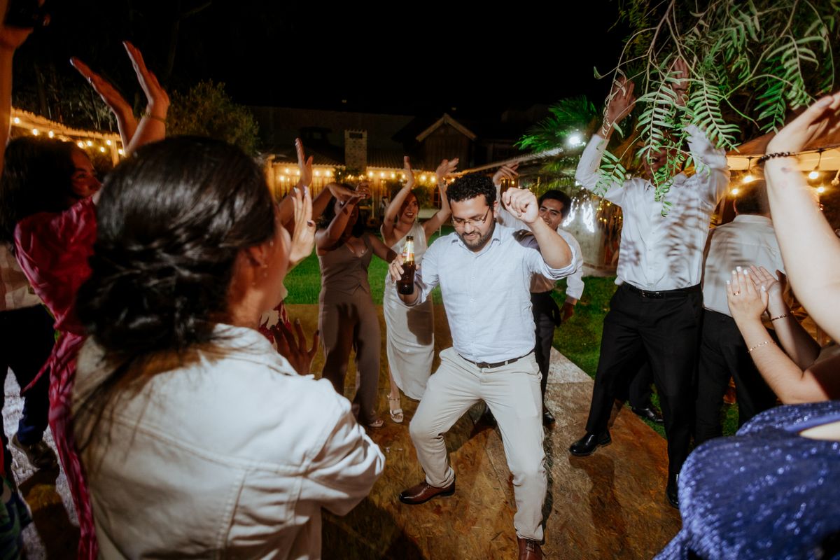 Wedding guests dancing together on a lit reception dance floor