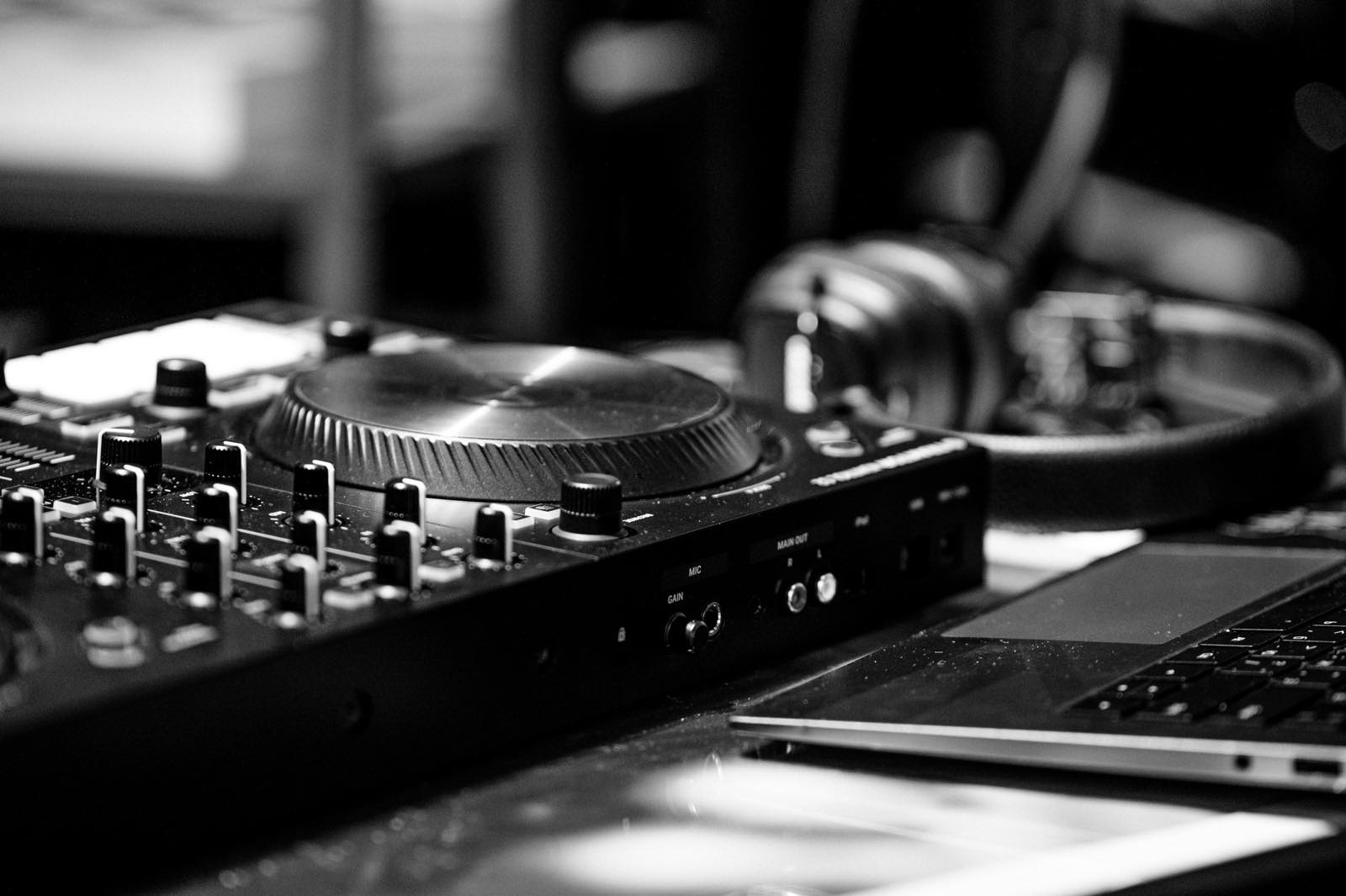 Close-up of DJ headphones and a laptop cart screen representing per-track beatport pricing