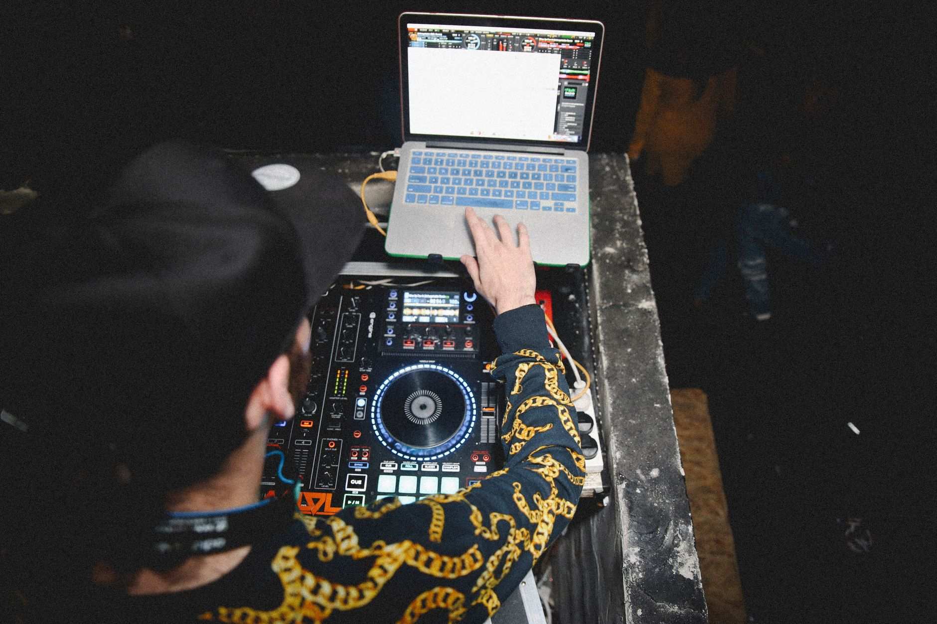 DJ comparing dj pool subscription pricing plans on a laptop before a weekend gig