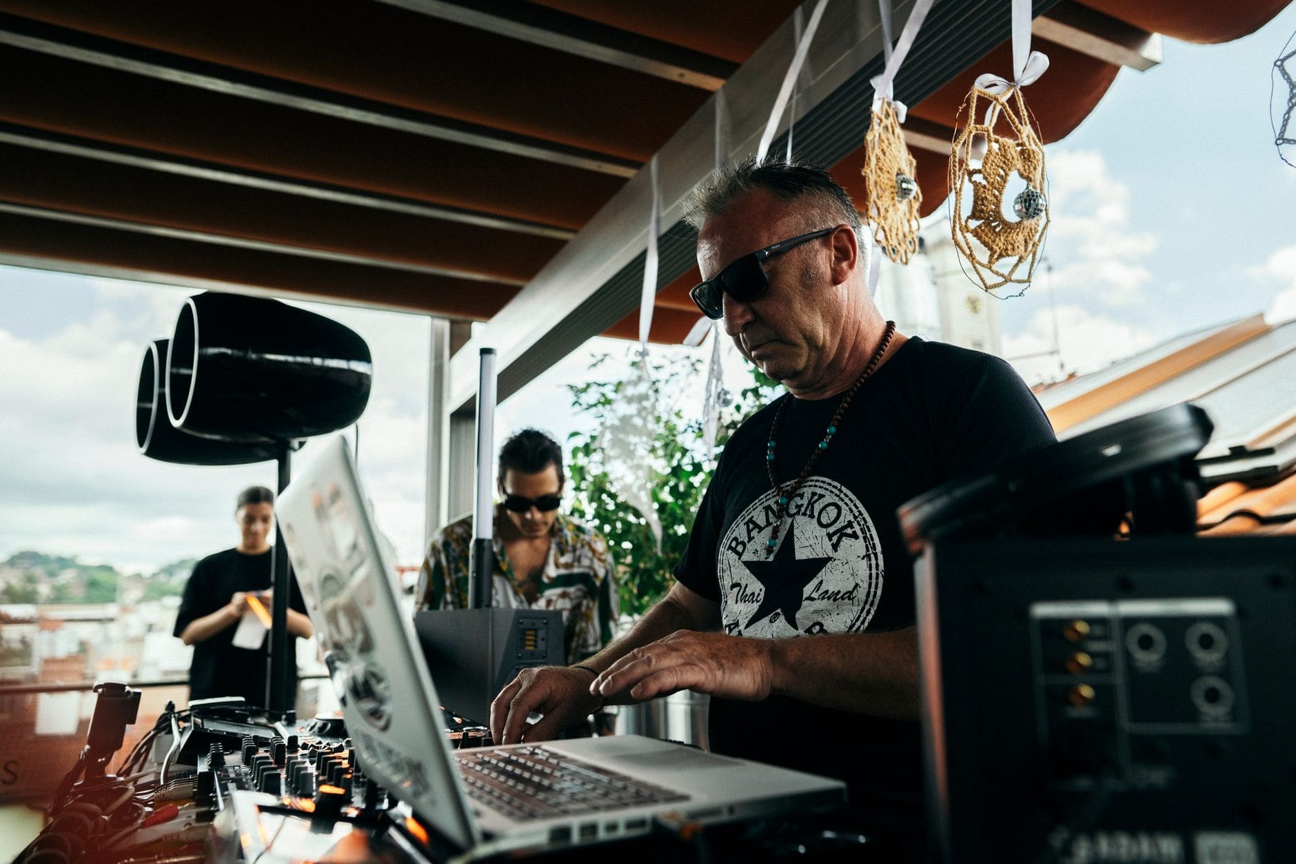 Close-up of a DJ tagging tracks by genre, BPM, and energy on a laptop before a gig