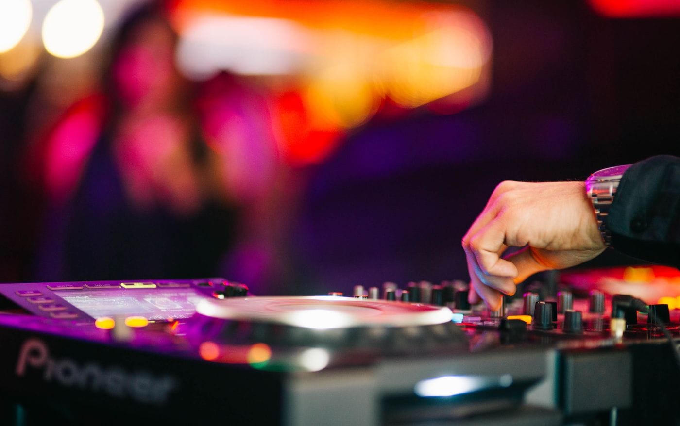 DJ working the mixer in a nightclub while reading the crowd's requests