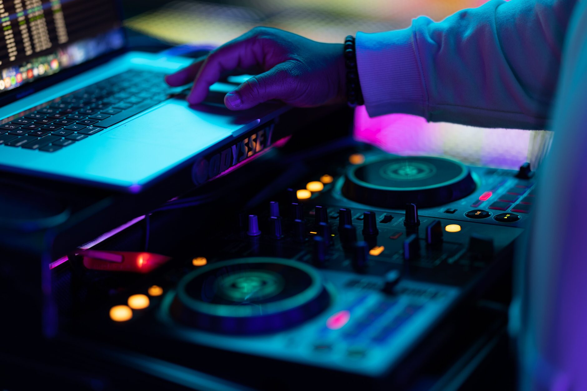 DJ focused on a laptop and controller, reading the crowd mid-set