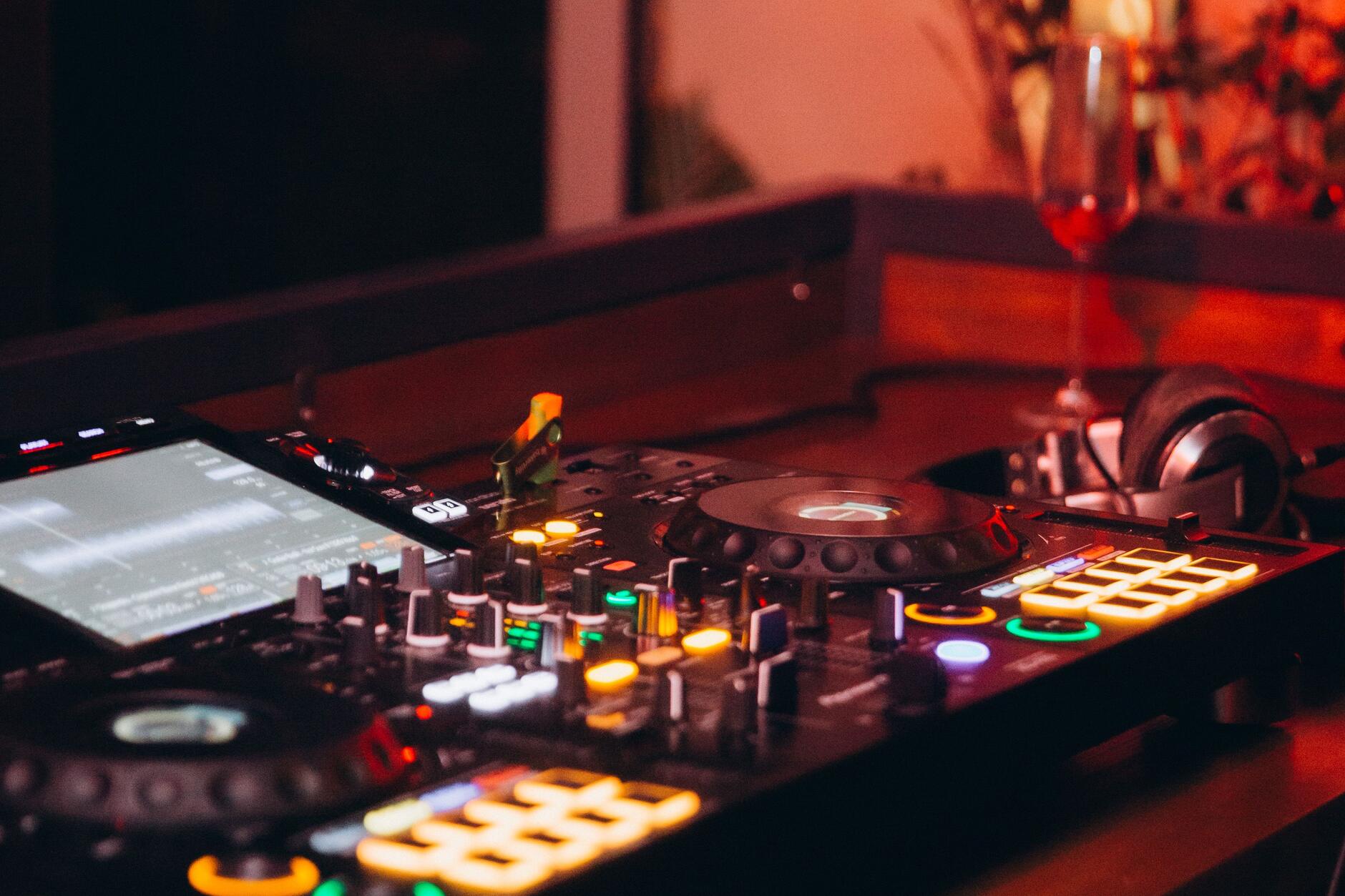 Close-up of a DJ mixer with sync and cue buttons lit up during a set