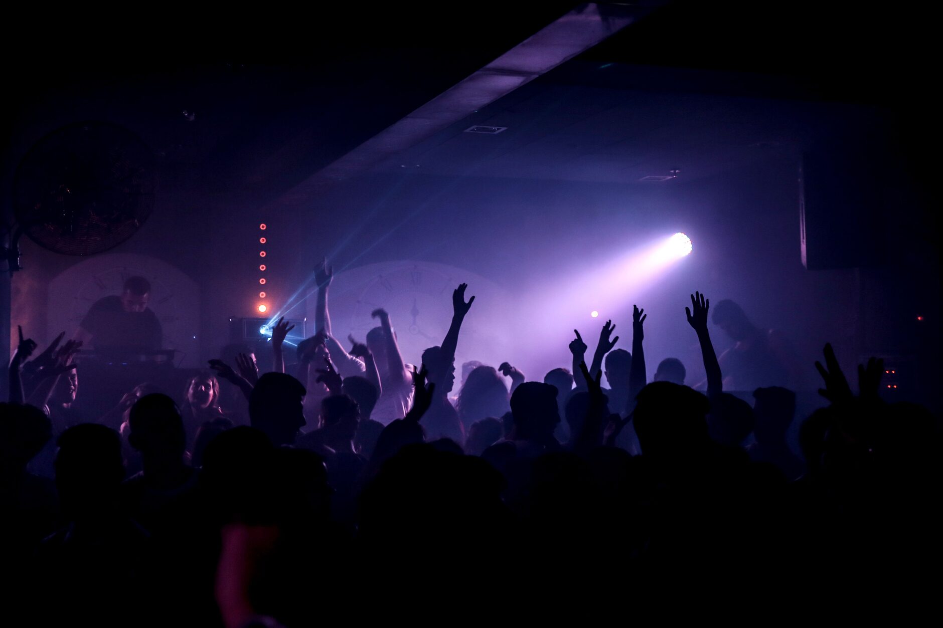 DJ playing to a full dance floor at night, crowd energy high