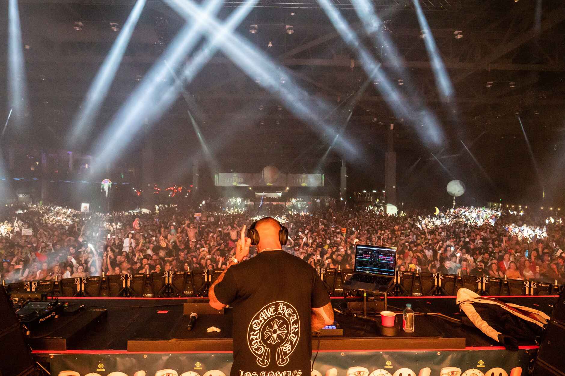 A DJ playing a packed festival set built from a curated, multi-source music library