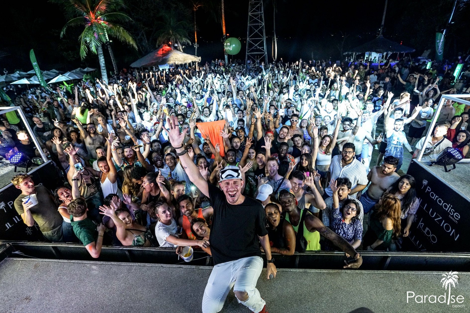 Crowd raised hands at a paradise beach gig